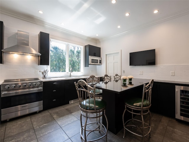 4 Terrace Ct, Port Washington, NY 11050 - kitchen featuring stainless steel range, wall chimney exhaust hood, dark cabinetry, white microwave, and beverage cooler