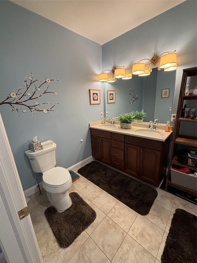 full bath featuring tile patterned floors, double vanity, a sink, and toilet