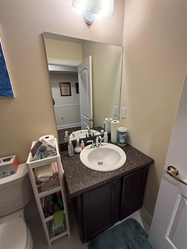 half bath featuring vanity and toilet