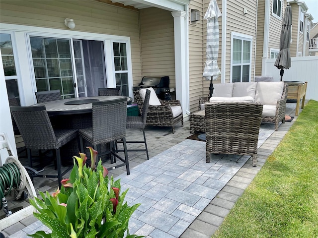 view of patio / terrace with an outdoor living space, outdoor dining space, and fence