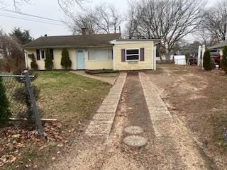 view of front facade featuring a front lawn, driveway, and a chimney