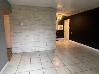 empty room with light tile patterned floors and a ceiling fan