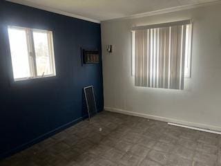 unfurnished room with crown molding, baseboards, and tile patterned floors