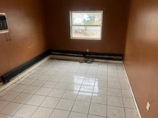 unfurnished room featuring light tile patterned floors and baseboards