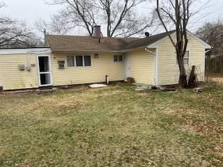 rear view of property with a yard and a chimney