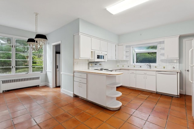 270 Bayberry Dr, Hewlett Harbor, NY 11557 - kitchen with radiator heating unit, open shelves, tasteful backsplash, white appliances, and a notable chandelier