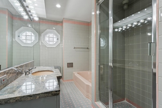 270 Bayberry Dr, Hewlett Harbor, NY 11557 - bathroom with tile walls, a garden tub, vanity, and a stall shower