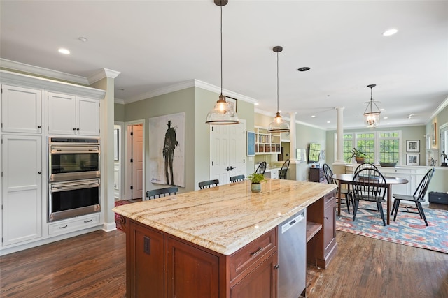 kitchen with stainless steel appliances, dark wood finished floors, decorative columns, decorative light fixtures, and ornamental molding