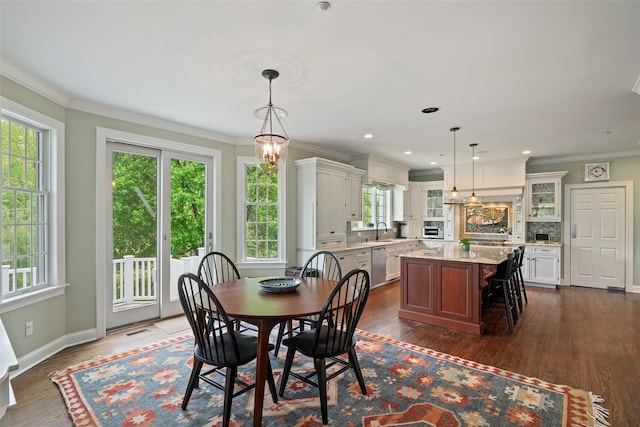dining room featuring dark wood-style flooring, crown molding, and baseboards