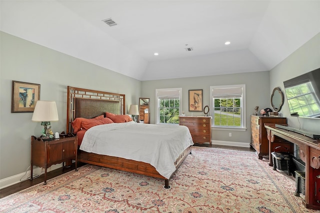 bedroom with multiple windows, baseboards, vaulted ceiling, recessed lighting, and wood finished floors