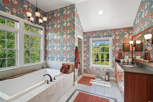 bathroom featuring plenty of natural light, tile patterned flooring, wallpapered walls, vanity, and a garden tub