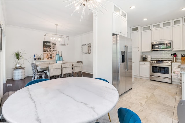 8 Alder Way, Armonk, NY 10504 - kitchen featuring white cabinetry, decorative backsplash, crown molding, a chandelier, and stainless steel appliances