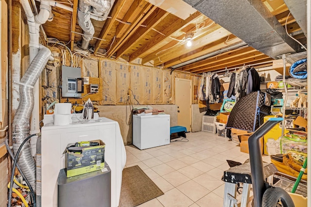13 Iris Cir, Beacon, NY 12508 - unfinished below grade area with separate washer and dryer, tile patterned flooring, electric panel, and refrigerator