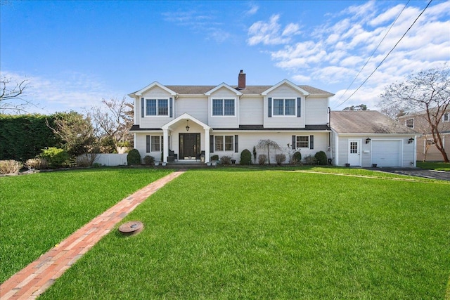view of front of home with driveway, a chimney, a front yard, and a garage
