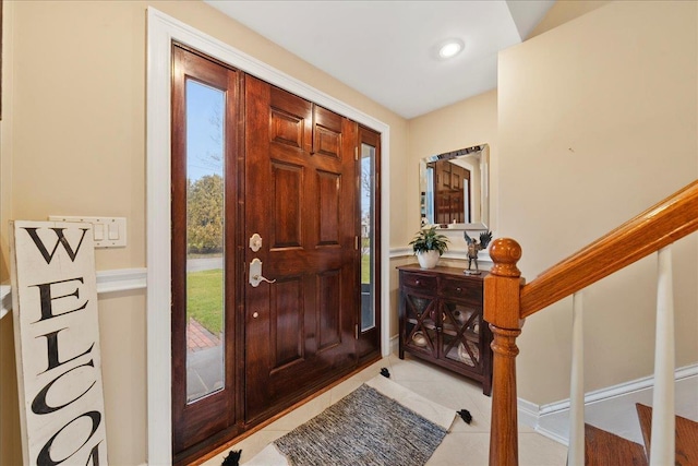 entrance foyer with light tile patterned flooring and stairway
