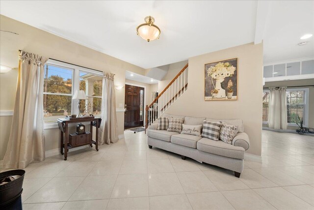 living room with light tile patterned flooring, stairway, and baseboards