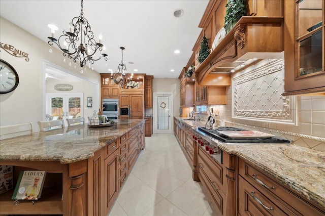 kitchen featuring open shelves, brown cabinetry, a sink, a chandelier, and tasteful backsplash
