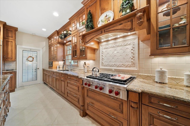 kitchen with stainless steel gas stovetop, tasteful backsplash, and brown cabinetry