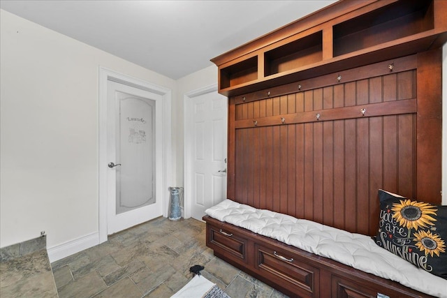 mudroom featuring baseboards and stone finish floor