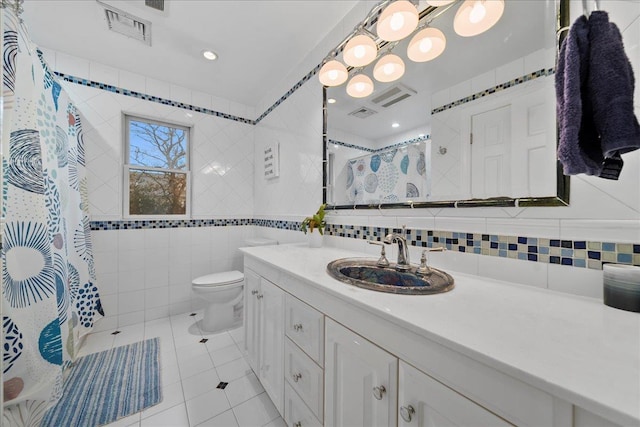 bathroom featuring vanity, tile walls, toilet, tile patterned flooring, and visible vents
