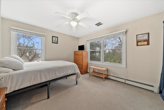 bedroom with light carpet, baseboard heating, visible vents, and multiple windows