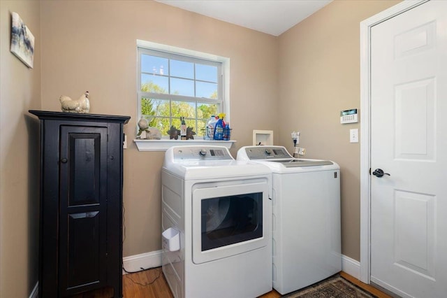 laundry room with laundry area, washer and clothes dryer, baseboards, and wood finished floors