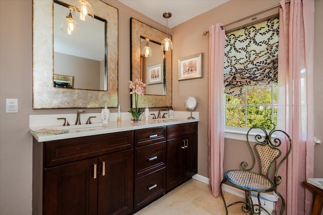 bathroom featuring double vanity, a sink, baseboards, and tile patterned flooring