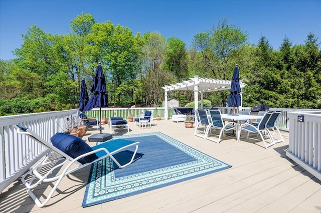 view of pool with a wooden deck, outdoor dining area, and a pergola