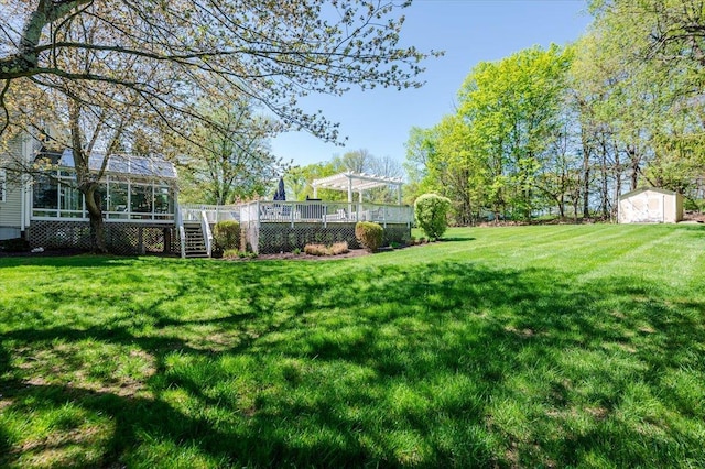 view of yard with a storage unit, a pergola, a wooden deck, stairway, and an outdoor structure