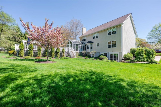 rear view of property featuring stairs, a chimney, and a yard