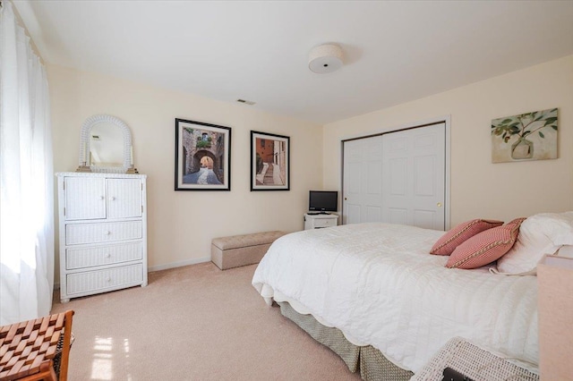 bedroom with baseboards, visible vents, carpet, and a closet