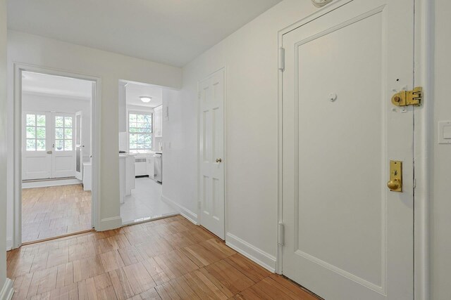 hallway with light wood-type flooring and baseboards