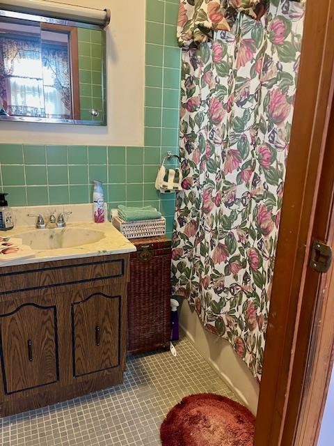bathroom with tile patterned floors, vanity, and tile walls