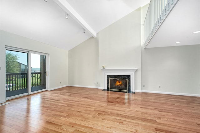 55 Waters Edge Unit 55, Rye, NY 10580 - unfurnished living room with high vaulted ceiling, rail lighting, light wood-style floors, a fireplace, and beam ceiling