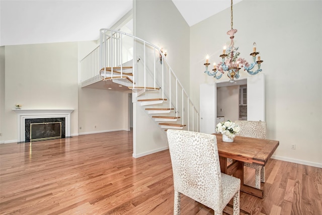 55 Waters Edge Unit 55, Rye, NY 10580 - dining area with high vaulted ceiling, stairway, a chandelier, wood finished floors, and a fireplace