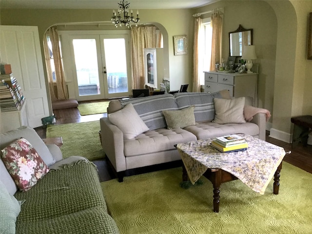 535 Beechwoods Rd, Callicoon, NY 12723 - living room featuring arched walkways, french doors, wood finished floors, and a chandelier