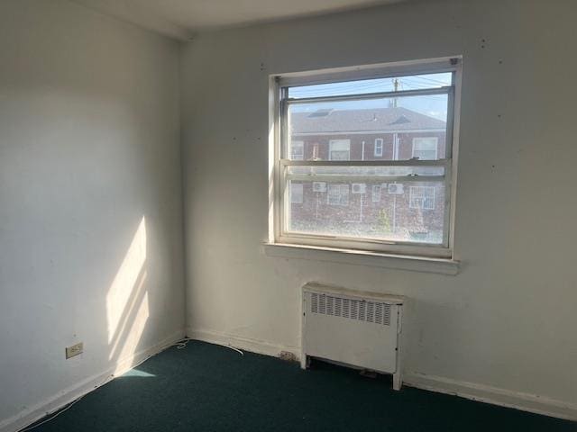 20-25 Parsons Blvd, Whitestone, NY 11357 - spare room with radiator, dark colored carpet, and baseboards