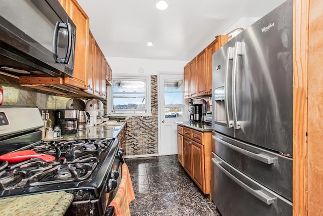 kitchen featuring granite finish floor, recessed lighting, brown cabinets, and appliances with stainless steel finishes