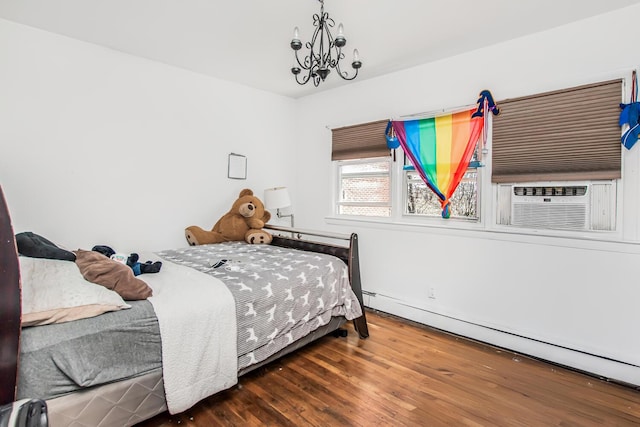 bedroom with cooling unit, baseboard heating, wood finished floors, and a chandelier