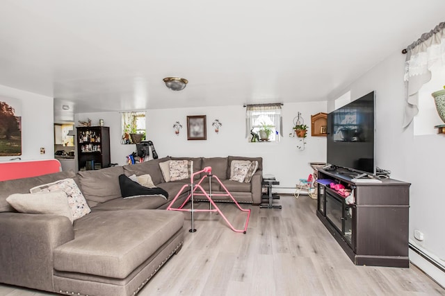 living room featuring a baseboard heating unit, baseboard heating, wood finished floors, and a wealth of natural light