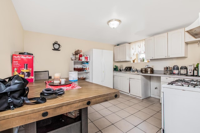 3650 Waldo Ave Unit 2, Bronx, NY 10463 - kitchen featuring white appliances, light tile patterned flooring, white cabinetry, light countertops, and extractor fan