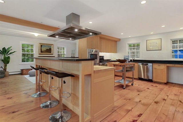 27 Dingle Ridge Rd, North Salem, NY 10560 - kitchen with appliances with stainless steel finishes, island exhaust hood, light wood-style flooring, baseboard heating, and dark countertops