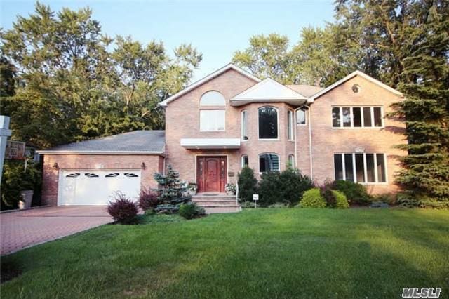 8 Percheron Ln, Roslyn Heights, NY 11577 - traditional home featuring a garage, a front yard, and concrete driveway
