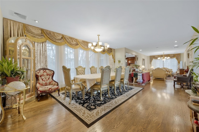 8 Percheron Ln, Roslyn Heights, NY 11577 - dining space with visible vents, wood finished floors, and an inviting chandelier