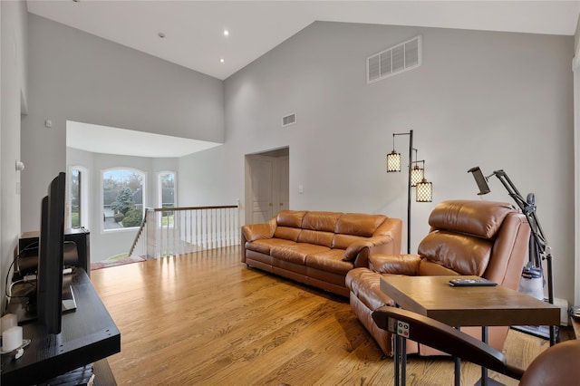 8 Percheron Ln, Roslyn Heights, NY 11577 - living room featuring light wood finished floors, visible vents, and high vaulted ceiling