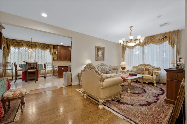 8 Percheron Ln, Roslyn Heights, NY 11577 - living area featuring wood finished floors, a chandelier, visible vents, and baseboard heating