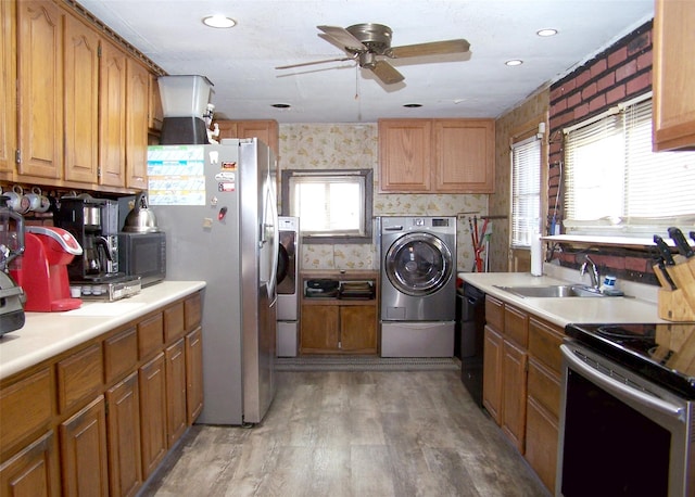 kitchen with stainless steel appliances, a wealth of natural light, washing machine and clothes dryer, ceiling fan, and a sink