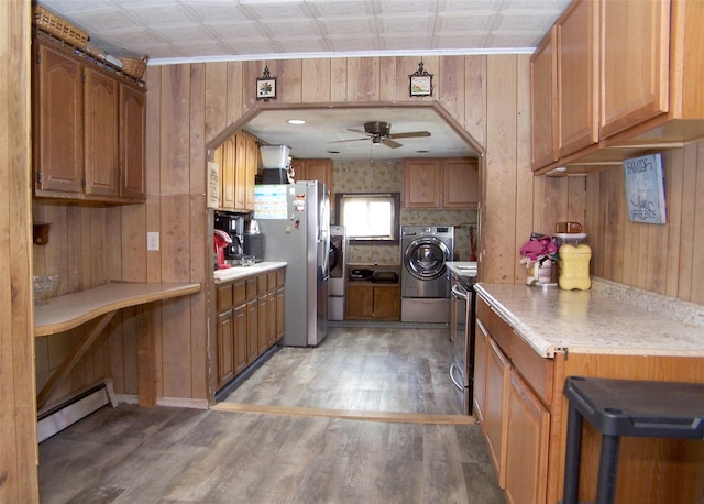 kitchen featuring wood walls, washer and dryer, light wood finished floors, and a baseboard radiator