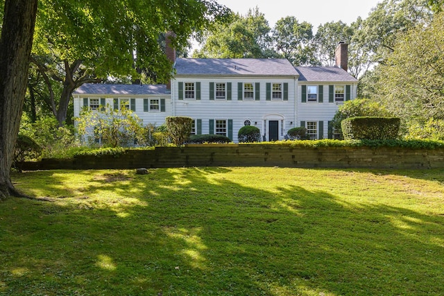 view of front of home featuring a front lawn and a chimney
