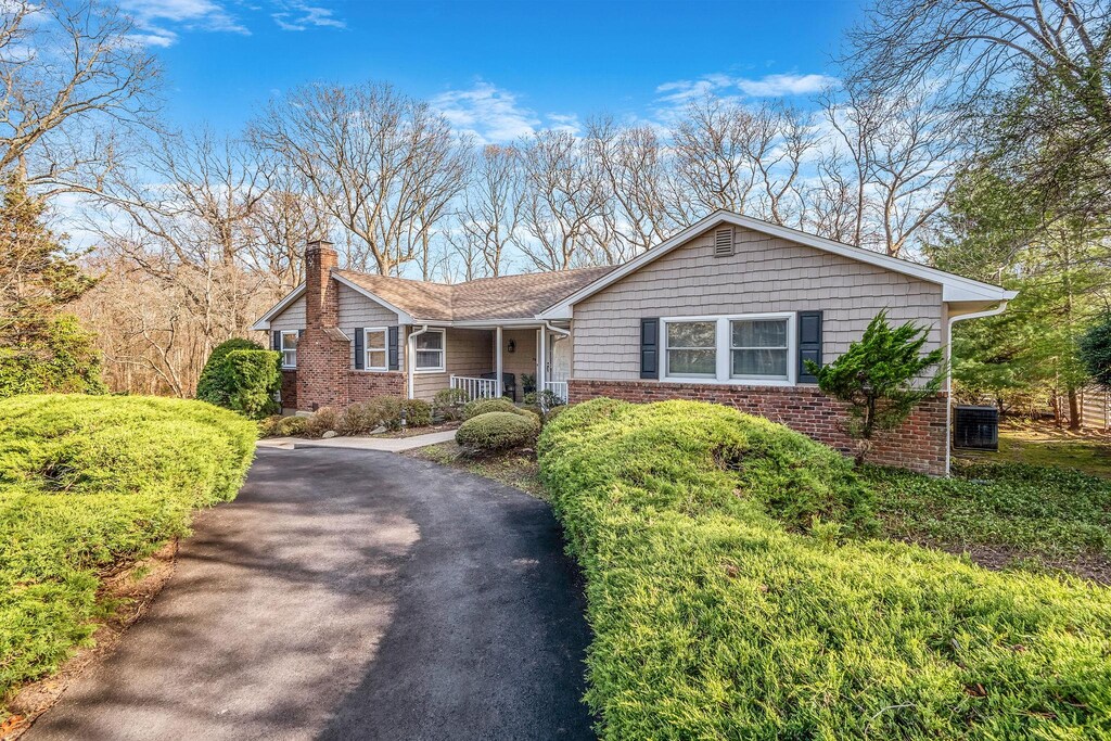 714 Brewster Dr, Port Jefferson, NY 11777 - ranch-style home with a porch, a chimney, aphalt driveway, and brick siding